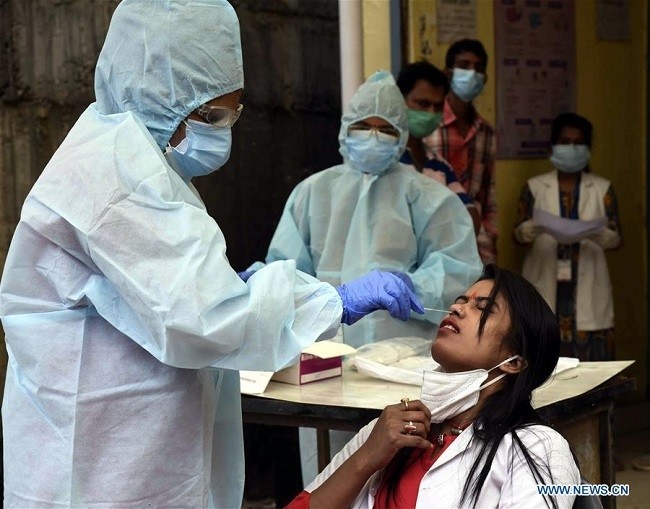 A medical worker collects a swab sample from a woman at a COVID-19 screening centre in Patna, India's Bihar state, on July 21, 2020. (Photo: Xinhua)