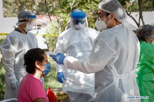 A medical worker checks body temperature of a woman in Mexico City, Mexico, July 22, 2020. Mexico's Health Ministry on Wednesday reported 6,019 new confirmed COVID-19 cases, bringing the total in the country to 362,274 cases. (Photo: Xinhua)