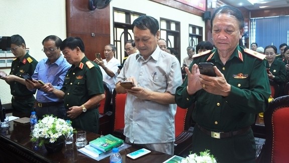 Delegates send text messages to support former Truong Son soldiers at the launching ceremony (Photo: qdnd.vn)