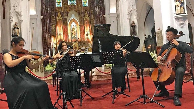 Cellist Phan Do Phuc (right) performing with the cello at the Saint Joseph Cathedral in Hanoi. 