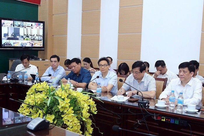Deputy PM Vu Duc Dam (third from right) chairs the virtual meeting with hospitals on COVID-19 treatment. (Photo: VGP)