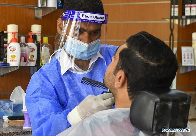  A barber wearing personal protective equipment serves a customer in Doha, capital of Qatar, July 30, 2020. As of Friday, the overall confirmed cases in Qatar has reached 110,695 and 174 had died of the disease. (Photo: Xinhua)