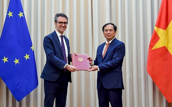 Permanent Deputy Minister of Foreign Affairs Bui Thanh Son (R) hands over a diplomatic note notifying the Vietnamese National Assembly's ratification of the EVFTA and EVIPA to Ambassador of the EU to Vietnam Giorgio Aliberti on June 18 in Hanoi. (Photo: Ministry of Foreign Affairs)