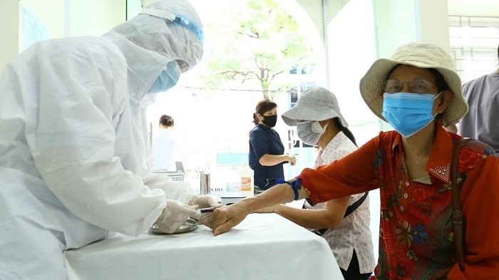 Health workers take quick samples for people returning from Da Nang. (Photo: VNA)