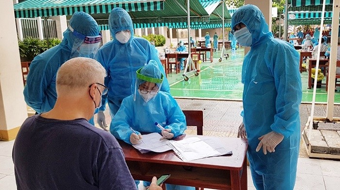Volunteers support a foreigner in health declaration in a blockade area at Thach Thang Ward, Hai Chau District, Da Nang City. (Photo: NDO/Tue Tam)