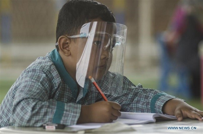 An elementary school student wearing a face shield studies in the classroom during face to face learning in Soreang, Bandung, West Java, Indonesia, Aug. 5, 2020. (Photo: Xinhua)