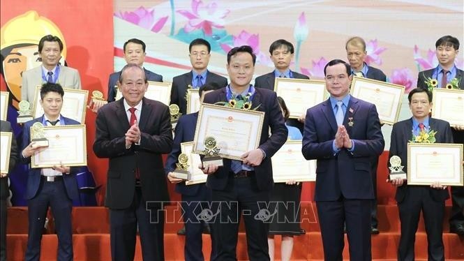 Deputy PM Truong Hoa Binh (first from left, front row) presents certificates to role models of the “All people protect national security” movement. (Photo: VNA)