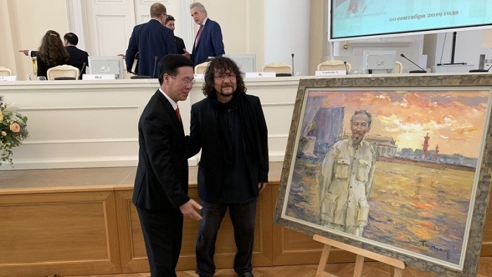 Russian artist Tuman Zhumabaev (R) and Politburo member Vo Van Thuong stand in front of one of Zhumabaev’s paintings depicting late President Ho Chi Minh, which was presented as a gift to the delegation of Vietnamese leaders during their visit to Russia in this photo captured on February 20, 2019. (Photo: Lilac Gallery)