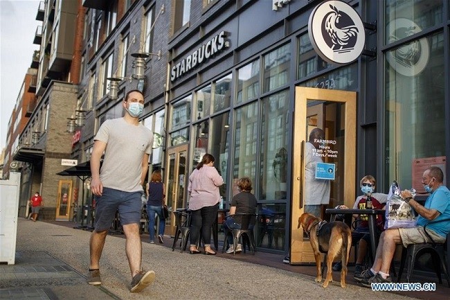A man wearing a face mask walks past a restaurant in Washington, D.C., the United States, Aug. 14, 2020. (Photo: Xinhua)