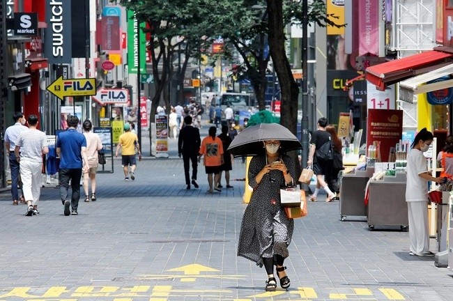 A woman wearing a mask walks down a street, as social distancing measures were implemented to avoid the spread of the coronavirus disease (COVID-19), in Myeongdong shopping district in Seoul, Republic of Korea, August 19, 2020. (Photo: Reuters)