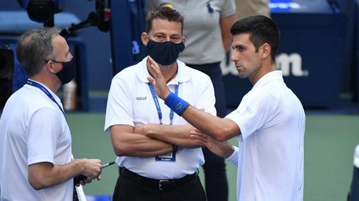 Sep 6, 2020; Flushing Meadows, New York, USA; Novak Djokovic discusses with a tournament official after being defaulted for striking a lines person with a ball against Pablo Carreno Busta (not pictured) on day seven of the 2020 US Open tennis tournament at USTA Billie Jean King National Tennis Centre. (Photo: USA TODAY Sports)