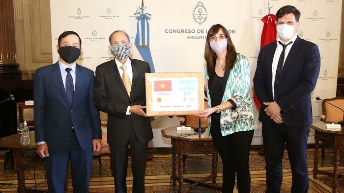Ambassador Dang Xuan Dung (second from left) presents the token of Vietnam's gift to Administrative Secretary of the Argentine Senate Maria Luz Alonso. (Photo: VNA)