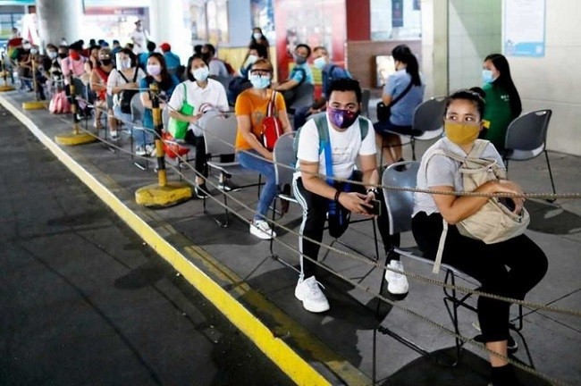 Passengers wearing masks for protection against COVID-19 maintain social distancing while queueing to ride a bus in Quezon City, Metro Manila, Philippines. (File Photo: Reuters)