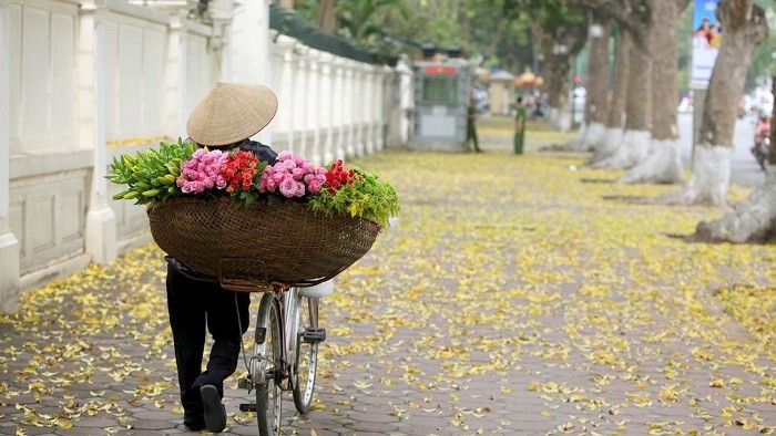 A florist vendor walking along the street 