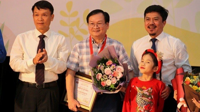 Writer Nguyen Nhat Anh (C) receives the Cricket Knight prize at the event. (Photo: VNA)