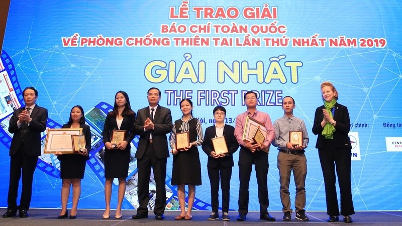 Agriculture minister Nguyen Xuan Cuong and UNDP Vietnam head Caitlin Wiese present the awards to winning writers.