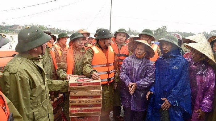 Deputy Prime Minister Trinh Dinh Dung (C) pays a visit to local people hit by record flooding in Hamlet 7, Cam Nghi Commune, Cam Xuyen District, Ha Tinh Province, October 20, 2020. (Photo: VGP)