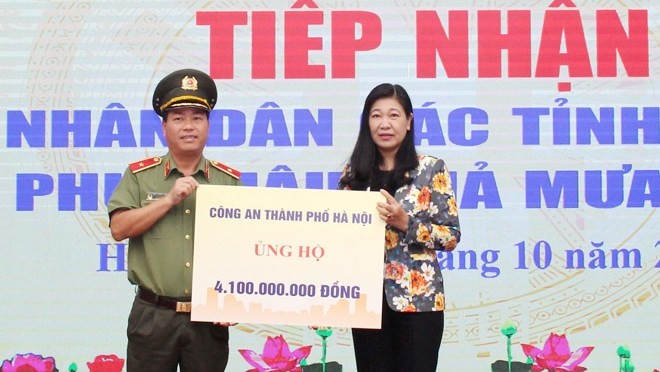 Chairwoman of the Vietnam Fatherland Front Committee, Hanoi chapter, Nguyen Lan Huong receives donations from organisations. (Photo: HNMO)
