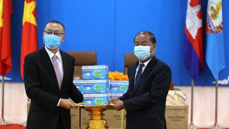 Vietnamese Ambassador to Cambodia Vu Quang Minh (L) hands over the face masks to Kem Sambath, member of the CPP Central Committee and Vice Chairman of the CPP Central Committee’s Commission for External Relations. (Photo: NDO)
