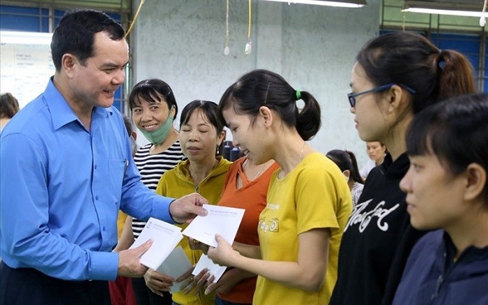 Nguyen Dinh Khang, President of the Vietnam General Confederation of Labour, presents gifts to workers at Quang Tri Garment Joint Stock Company who were affected by floods. (Photo: NDO/Phuc Quan)