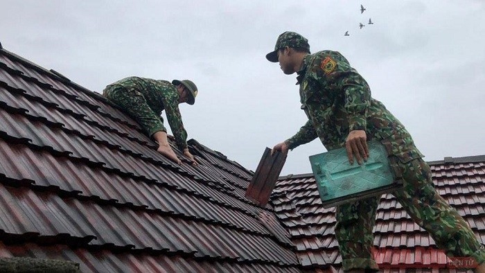 Quang Binh border guards help people in Bo Trach District to retile the rooves of their houses after being hit by Storm Vamco on November 15, 2020. (Photo: NDO)