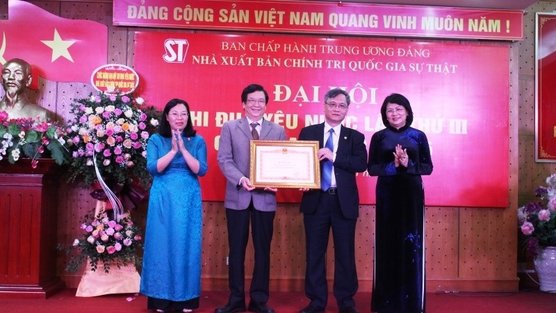Vice President Dang Thi Ngoc Thinh presents the PM's certificates of merit to the Truth National Political Publishing House. 