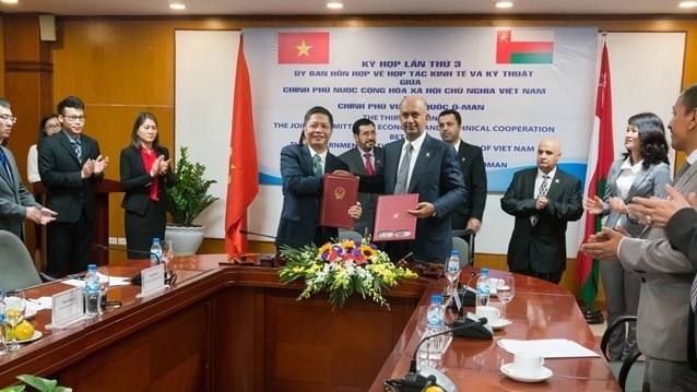 Vietnam’s Minister of Industry and Trade Tran Tuan Anh (L) and Omani Minister of Commerce and Industry Ali bin Masoud Al-Sunaidy sign a minute at the end of the third meeting of the Vietnam-Oman Joint Committee on Economic and Technical Cooperation, Hanoi, March 23, 2018. (Photo: NDO)
