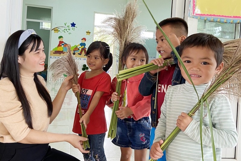 Teacher Dinh Thi Suong receives a bunch of reed flowers from schoolchildren. (Photo: NDO/Lam Quang Huy)