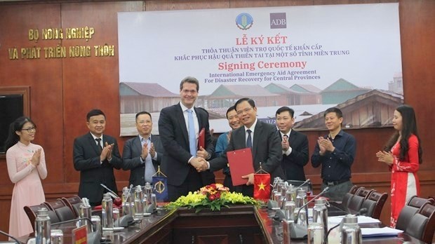 Minister of Agriculture and Rural Development Nguyen Xuan Cuong (front, right) and ADB Country Director Andrew Jeffries (front, left) at the signing ceremony on November 24 (Photo: VNA)