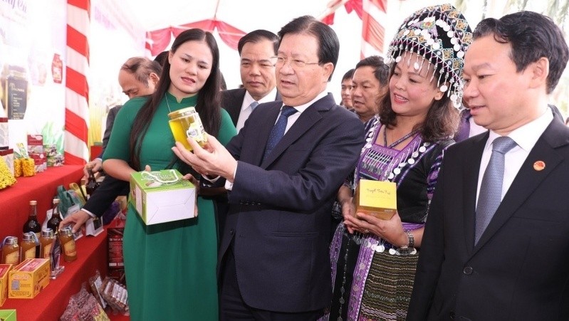 Deputy PM Trinh Dinh Dung visits a booth showcasing OCOP products on the sidelines of the conference.