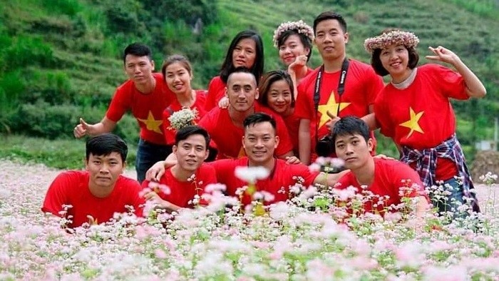 Visitors pose for a group photo amid a buckwheat flower filed in Ha Giang Province 