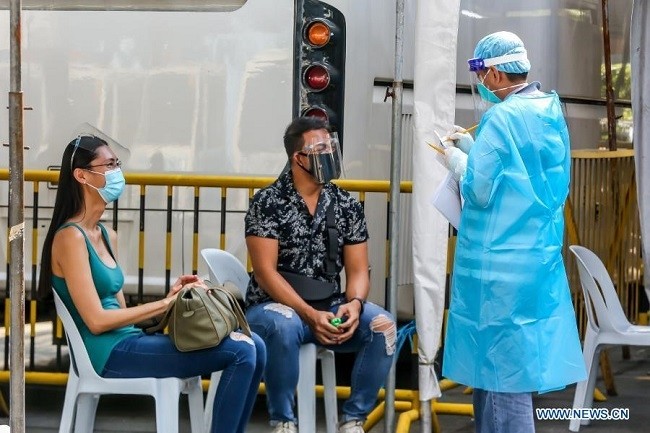 A medical worker surveys two residents before taking their COVID-19 swab samples in Manila, the Philippines, Dec. 14, 2020. The Department of Health (DOH) of the Philippines reported 1,339 new confirmed cases of COVID-19 infection on Monday, bringing the total number in the country to 450,733. (Photo: Xinhua)