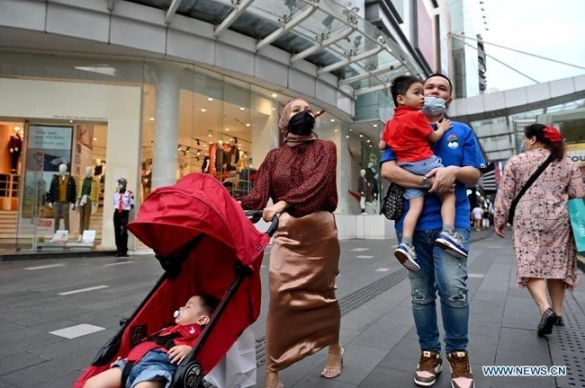 People wearing face masks walk on a street in Kuala Lumpur, Malaysia, Dec. 16, 2020. (Photo: Xinhua)