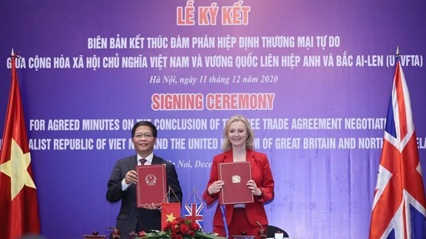Minister of Industry and Trade Tran Tuan Anh and UK Secretary of State for International Trade Elizabeth Truss sign the minutes on the conclusion of negotiations over the UKVFTA. (Photo: VNA)