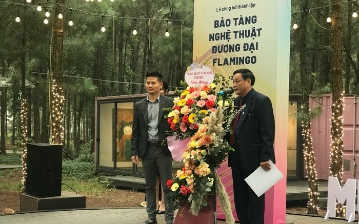 Deputy Director of the Vinh Phuc Provincial Department of Culture, Sports and Tourism Duong Quang Ung (R) presents congratulatory flowers to FCAM Director Vu Hong Nguyen.