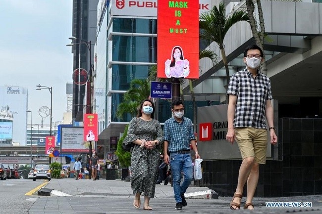 People wearing face masks walk on a street in Kuala Lumpur, Malaysia, Jan. 2, 2021. Malaysia on Saturday reported 2,295 new COVID-19 infections, bringing the national total to 117,373. (Photo: Xinhua)