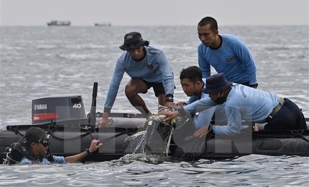 Divers from the naval force search for plane debris from the crash in the waters near Lancang Island, Indonesia, on January 10. (Photo: AFP/VNA)