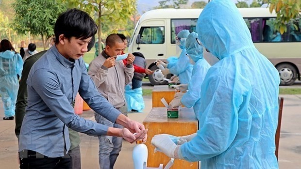 Vietnamese citizens wash their hands with sanitisers at a concentrated quarantine area. (Photo: VNA)