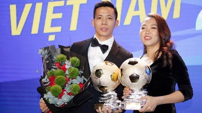 Forward and captain Nguyen Van Quyet (L) of Hanoi FC and striker Cu Thi Huynh Nhu of Ho Chi Minh City Club win the Golden Ball awards for player of the year (Photo: danviet.vn)