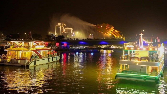 Cruises take visitors to see Dragon Bridge breathing water during a free tour to the river at night offered for the two nights of Jan 1 and 2, 2021. (Photo: VNA)