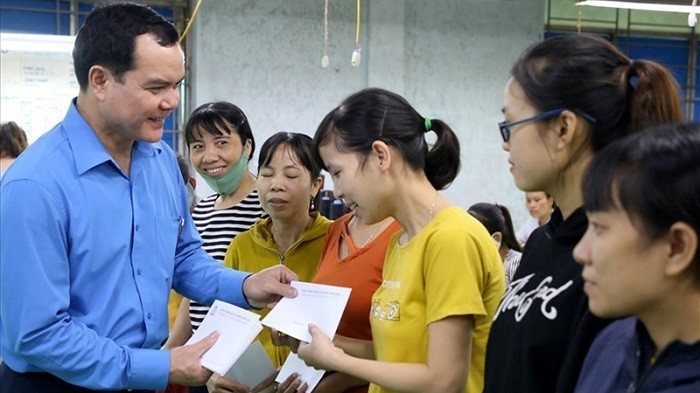 President of the Vietnam General Confederation of Labour Nguyen Dinh Khang (far left) presents gifts to workers at Quang Tri Garment Joint Stock Company who have been affected by the historic flooding in central Vietnam, November 2020. (Photo: Vietnam General Confederation of Labour)