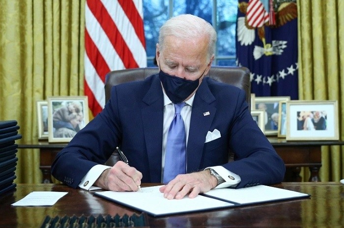 US President Joe Biden signs executive orders in the Oval Office of the White House in Washington, after his inauguration as the 46th President of the United States. (Reuters)