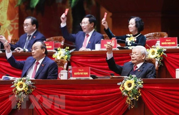 Party General Secretary and State President Nguyen Phu Trong (right, first row) and members of the Presidium vote to approve the working programme of the 13th National Party Congress. (Photo: VNA)