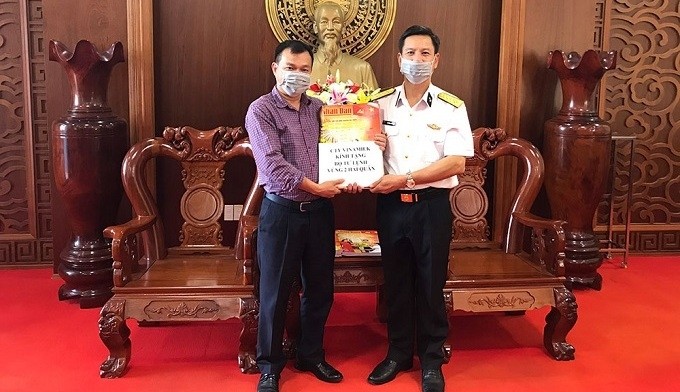 The political chairman of the Navy Region 2 High Command Do Hong Duyen (right) receives copies of spring edition of Nhan Dan Newspaper.
