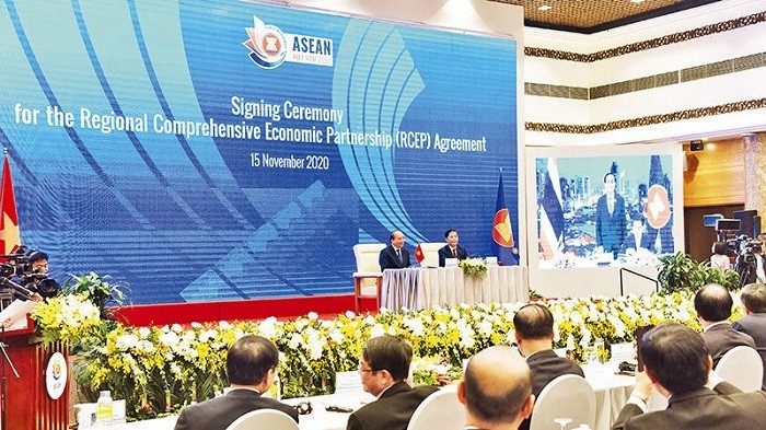 Prime Minister Nguyen Xuan Phuc (L), the Chair of ASEAN 2020, witnesses the signing of the Regional Comprehensive Economic Partnership. (Photo: Duc Anh)