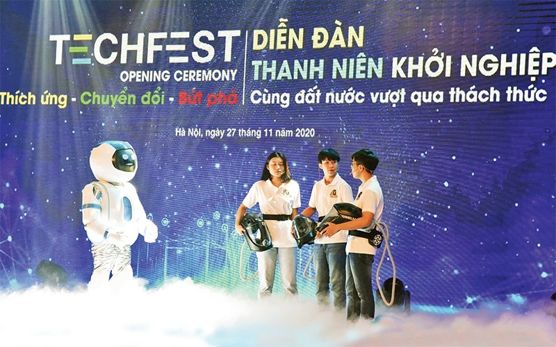 The dialogue between the robot and the authors of the Vietnam's anti-pandemic helmet (Vihelm) at the opening ceremony of the Youth Start-up Forum 2020. (Photo: DUC ANH)
