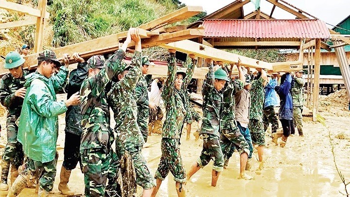 Officers and soldiers at Ga Ry Border Guard Station under the Border Guard Headquarters of Quang Nam Province helping peole in Tay Giang district rebuild their houses after the storm.