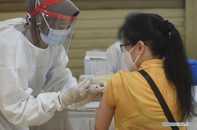 A woman receives a dose of the COVID-19 vaccine during a mass vaccination for traders at Tanah Abang textile market in Jakarta, Indonesia, Feb. 19, 2021. Indonesia on Wednesday began the second phase of its massive COVID-19 vaccination program. (Photo: Xinhua)