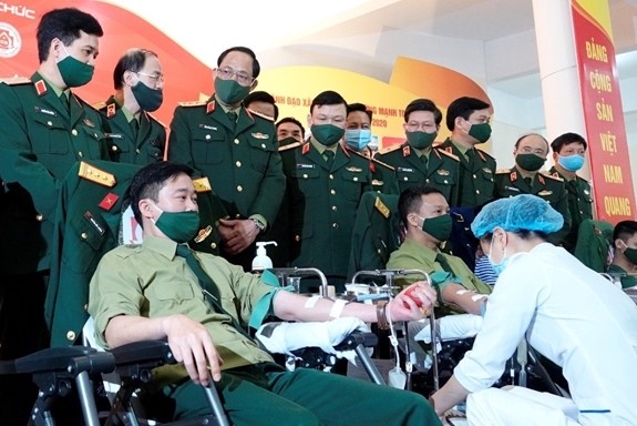 Senior Lieutenant Colonel Nguyen Duc Cuong, deputy head of the Army Youth Department (sitting on the left) participates in the army’s voluntary blood donation movement. (Photo: qdnd.vn)