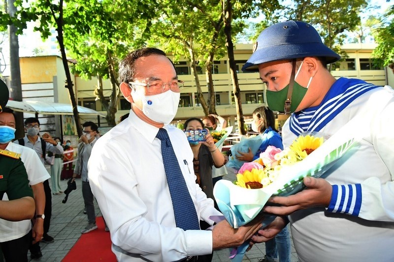 Politburo member and Secretary of the Ho Chi Minh City Party Committee Nguyen Van Nen presents flowers to a newly conscripted soldier at a ceremony to see off young people for military service in District 5, Ho Chi Minh City, March 3, 2021. (Photo: NDO)
